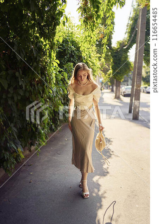 beautiful teenage girl in a silk skirt and a corset in the old money style strolls through the city 116654485