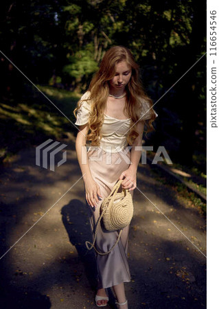 beautiful teenage girl in a silk skirt and a corset in the old money style walks in the park and along the river bank beautiful teenage girl in a silk skirt and a corset in the old money style walks in the park and along the river bank 116654546