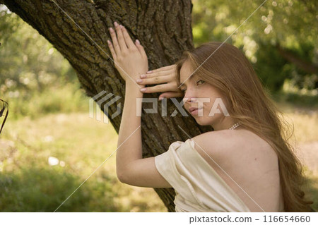 beautiful teenage girl in a silk skirt and a corset in the old money style walks in the park and along the river bank beautiful teenage girl in a silk skirt and a corset in the old money style walks in the park and along the river bank 116654660