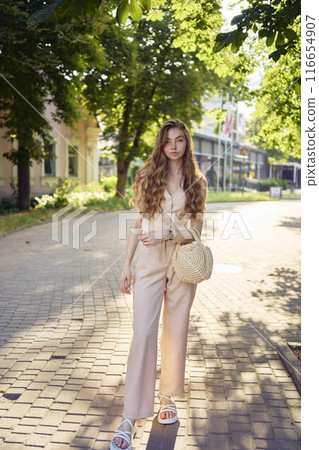 a beautiful teenage girl in a peach fuzz suit with a waistcoat, in the style of old money walks through the morning city a beautiful teenage girl in a peach fuzz suit with a waistcoat, in the style of old money walks through the morning city 116654907
