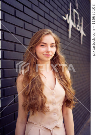 a beautiful teenage girl in a peach fuzz suit with a waistcoat, in the old money style walks through the morning city a beautiful teenage girl in a peach fuzz suit with a waistcoat, in the old money style walks through the morning city 116655108