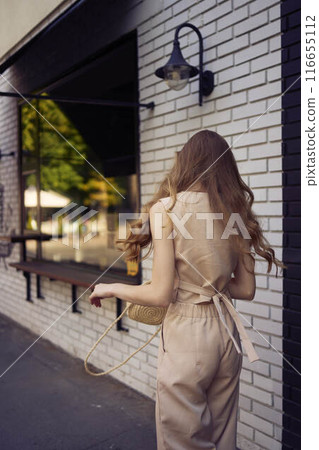 a beautiful teenage girl in a peach fuzz suit with a waistcoat, in the old money style walks through the morning city a beautiful teenage girl in a peach fuzz suit with a waistcoat, in the old money style walks through the morning city 116655112