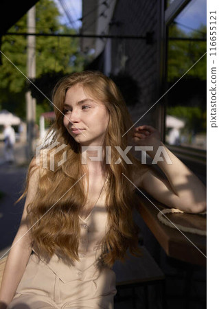 a beautiful teenage girl in a peach fuzz suit with a waistcoat in the old money style sits at the bar outside a beautiful teenage girl in a peach fuzz suit with a waistcoat in the old money style sits at the bar outside 116655121