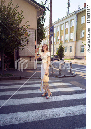 beautiful teenage girl in a silk skirt and a corset in the old money style strolls through the city 116655125