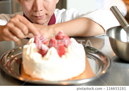 A male pastry chef making a whole cake 116655281