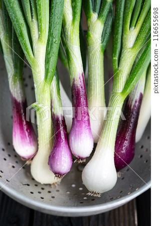 Heap of white and purple onions placed in a metal colander 116655698