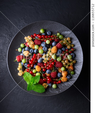 Multicolored assorted mix berries in a black plate Multicolored assorted mix berries in a black plate 116655712