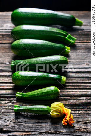 Zucchini laid out on a rustic wooden table in a row Zucchini laid out on a rustic wooden table in a row 116655733