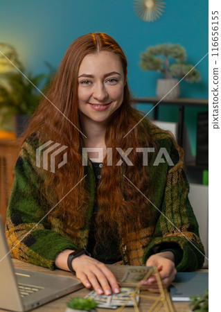 Business woman counting money cash and using laptop calculates dividends profits finances at office 116656155