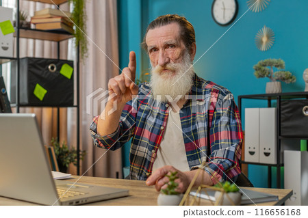 Senior man working on laptop shakes finger and saying No advice to avoid danger mistake disapproval Senior man working on laptop shakes finger and saying No advice to avoid danger mistake disapproval 116656168