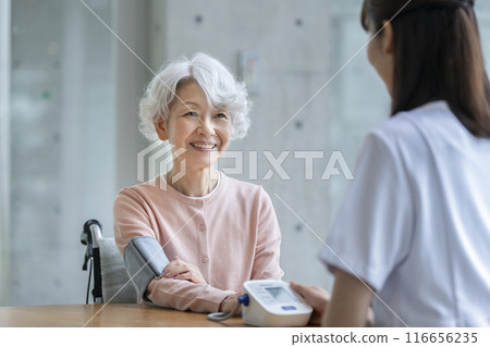 Senior woman having her blood pressure measured by a nurse Senior woman having her blood pressure measured by a nurse 116656235