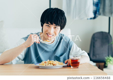 young man eating fried rice young man eating fried rice 116656488