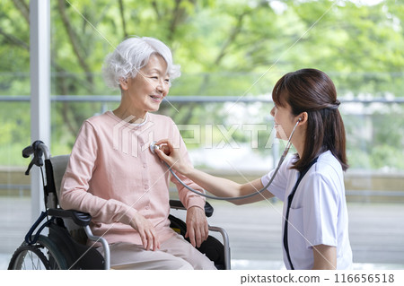 護理師給一位老年婦女使用聽診器 護理師給一位老年婦女使用聽診器 116656518