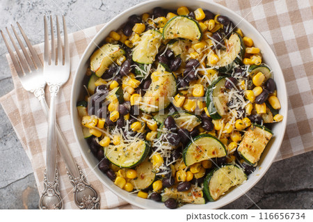 Vegetarian salad of roasted zucchini, black beans, corn, garlic and parmesan close-up in a bowl. Horizontal top view Vegetarian salad of roasted zucchini, black beans, corn, garlic and parmesan close-up in a bowl. Horizontal top view 116656734