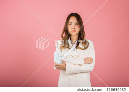 Arm broken. Unhappy business woman confident smiling broken arm after accident and wear arm splint for treatment, Asian female sling support hand studio isolated on white background, copy space 116656985