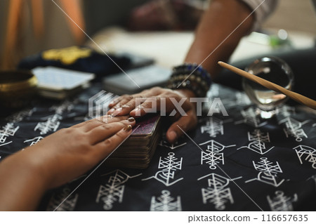 Female client and fortune teller touching deck of cards tarot cards. Forecasting and divination concept 116657635