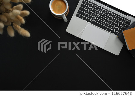 A cup of coffee, laptop and books on black background. Top view with copy space 116657648