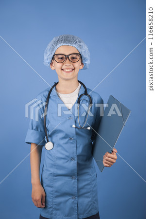 brunette boy doctor in a medical gown with a stethoscope. studio photo. My future profession concept 116658210