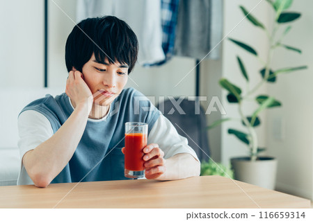 一個年輕人喝蔬菜汁 一個年輕人喝蔬菜汁 116659314