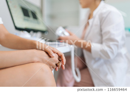 Closeup cropped shot of nervous female patient listening physician explaining clinic examination. Practitioner doctor providing medical consultation at healthcare visit at table with computer Closeup cropped shot of nervous female patient listening physician explaining clinic examination. Practitioner doctor providing medical consultation at healthcare visit at table with computer 116659464