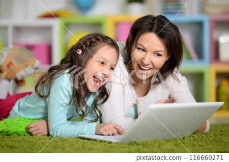 Happy laughing mother and little cute daughter using laptop 116660271