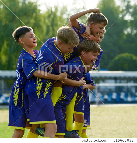 Smiling friends, boys jumping and hugging, expressing happiness and excitement after winning soccer game on outdoor stadium Smiling friends, boys jumping and hugging, expressing happiness and excitement after winning soccer game on outdoor stadium 116663052