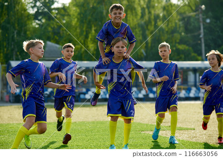 Group of happy and excited boys, children in sportswear running on field, expressing happiness and success after winning match Group of happy and excited boys, children in sportswear running on field, expressing happiness and success after winning match 116663056