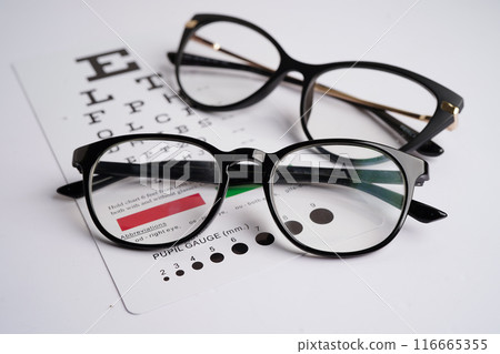 Glasses on eye exam chart to test eyesight accuracy of reading. Glasses on eye exam chart to test eyesight accuracy of reading. 116665355