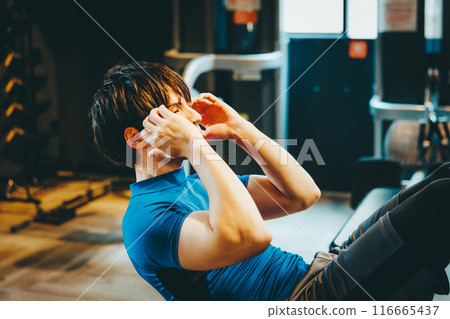 Man training his abdominal muscles at the gym Man training his abdominal muscles at the gym 116665437