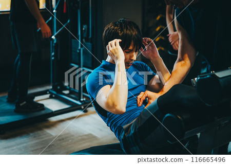 一名男子在健身房接受教練的指導 一名男子在健身房接受教練的指導 116665496