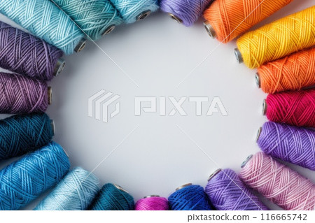 Colorful thread spools forming a circle. Colorful thread spools forming a circle. 116665742