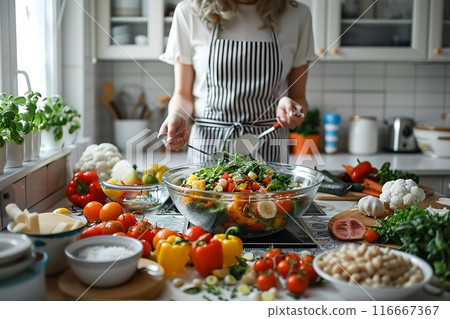 Modern kitchen with vegetables on the table. Bright white kitchen with household utensils. Healthy living concept Modern kitchen with vegetables on the table. Bright white kitchen with household utensils. Healthy living concept 116667367