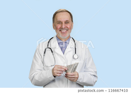 Portrait of a smiling male doctor is counting money. Isolated on blue. 116667410