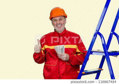 Portrait of smiling elder man with dollar baknotes showing like gesture. Handyman construction worker with his salary. Isolated on white. 116667484