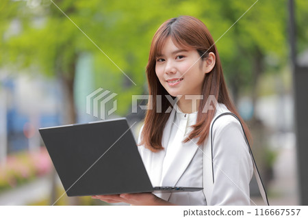 在綠色城市打開筆記型電腦的女商人_1 在綠色城市打開筆記型電腦的女商人_1 116667557