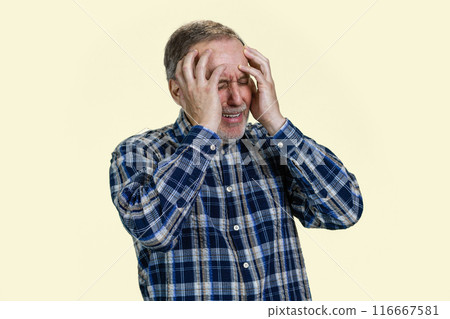 Portrait of senior man holds his head with both hands because of headache or disappontment. Isolated on white. Portrait of senior man holds his head with both hands because of headache or disappontment. Isolated on white. 116667581
