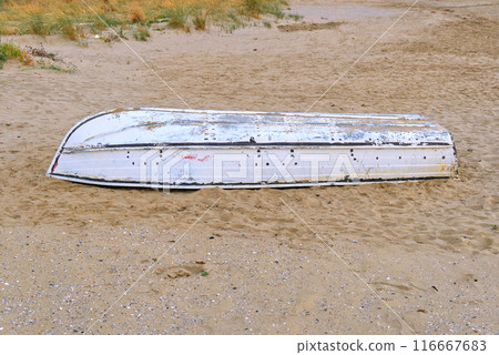 a small white boat capsized on the beach or in the desert a small white boat capsized on the beach or in the desert 116667683