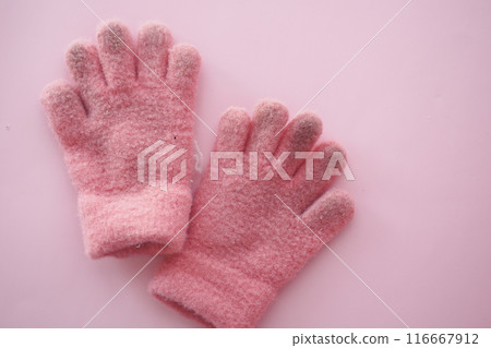 Cozy pink fluffy gloves on pink background, ideal for winter, keeping hands warm and stylish Cozy pink fluffy gloves on pink background, ideal for winter, keeping hands warm and stylish 116667912