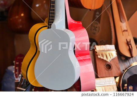 Row of colorful guitars hanging Row of colorful guitars hanging 116667924