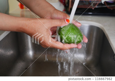 hand washing avocado with water sprinkling 116667982