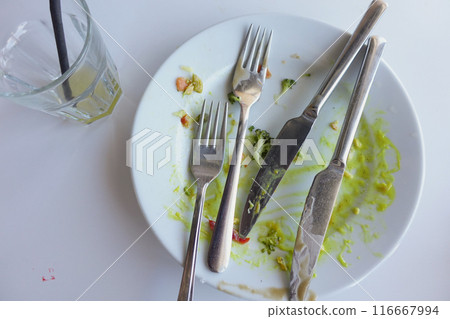 An empty dirty plate with a fork. 116667994