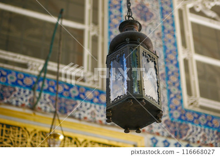 Ornate lantern with vibrant tile background, intricate craftsmanship and traditional design 116668027
