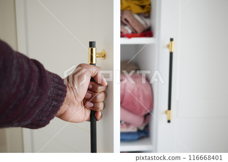 The closet has efficiently arranged shelves with neatly folded clothes when opened The closet has efficiently arranged shelves with neatly folded clothes when opened 116668401