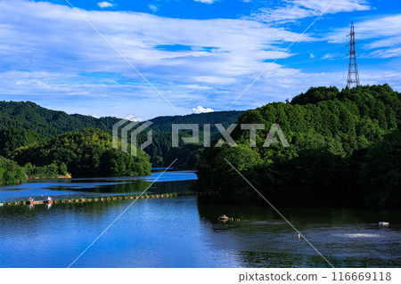 Evening view of Nunome Dam in the summer of 2024. Nunome Dam Lake is filled to the brim and reflects the blue sky. #1 116669118