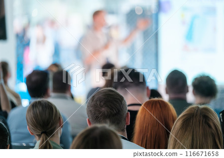 Audience attending a speaker at business conference with presentation Audience attending a speaker at business conference with presentation 116671658