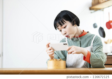 年輕女子為她的午餐盒拍照 年輕女子為她的午餐盒拍照 116672125