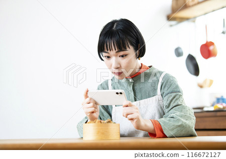 年輕女子為她的午餐盒拍照 年輕女子為她的午餐盒拍照 116672127