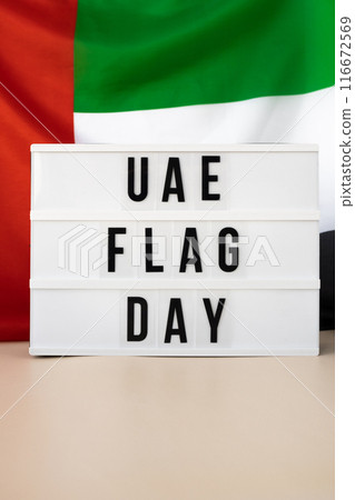Message with text UAE FLAG DAY on United Arab Emirates waving flag made from silk material. Independence Commemoration Day Muslim Public holiday celebration background. The National Flag of UAE 116672569
