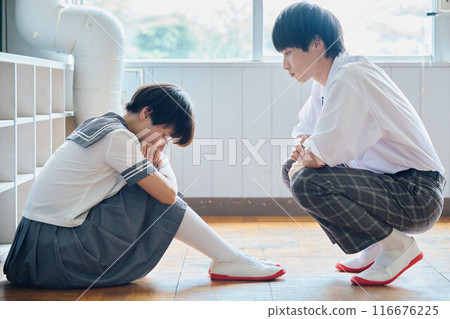 A high school boy reaching out to a depressed female student 116676225