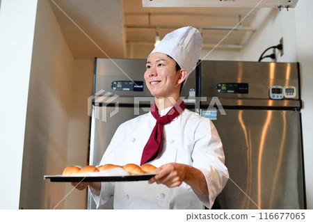 Smiling Asian man making bread in the kitchen Smiling Asian man making bread in the kitchen 116677065